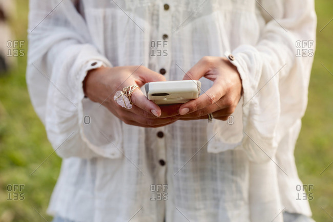 Woman in flowy blouse holding phone