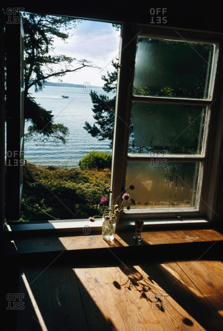 Open window view looking towards lake inside a summer cottage
