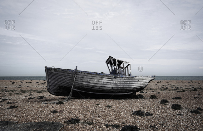 Old abandoned wooden boat washed up on a beach