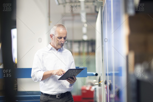 Engineer with digital tablet controlling industrial plant