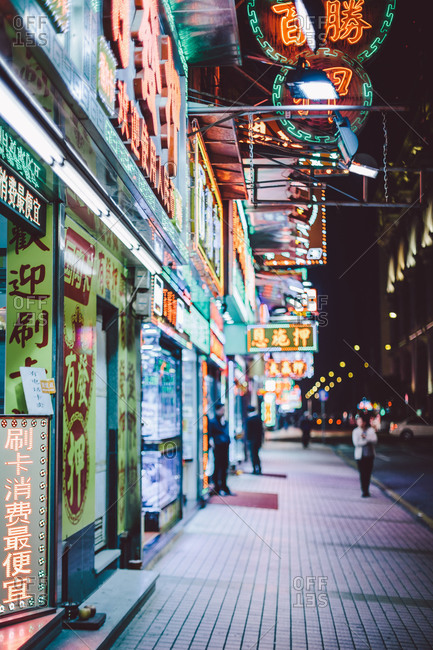 Storefronts and street at night in Macau