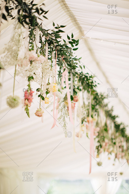 Garland of fresh flowers decorating tent for wedding reception