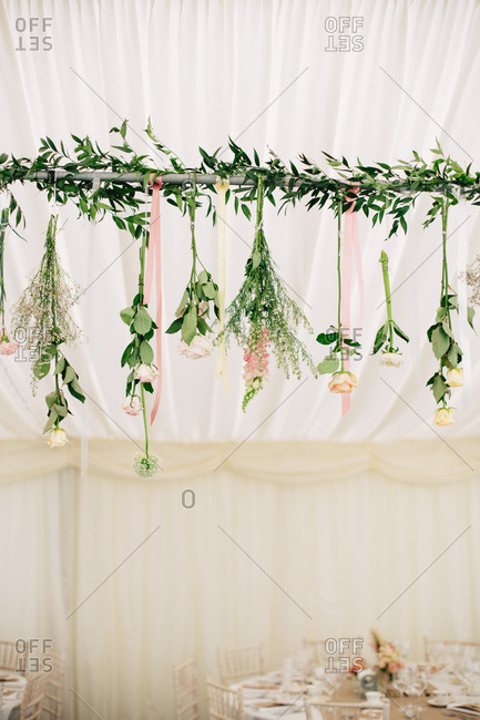 Garland of fresh flowers handing from tent pole for wedding reception