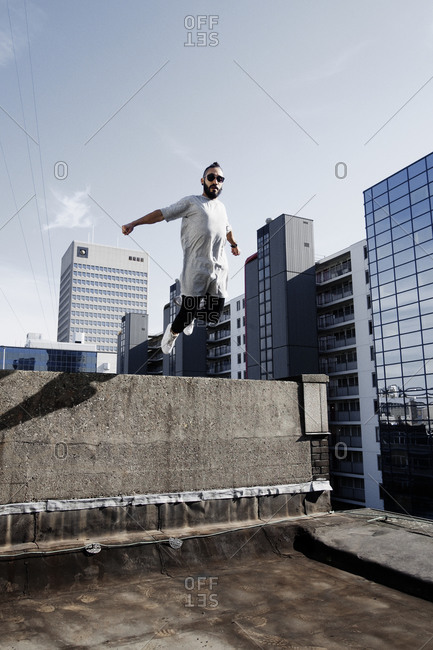 Young man doing parkour on a rooftop