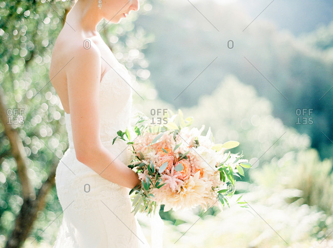 Side view of bride holding wedding bouquet