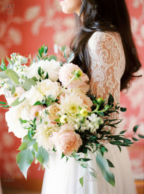 Bride holding wedding bouquet of pale pink and white flowers