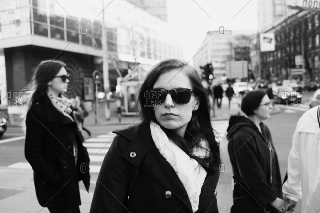 Black and white photo of woman walking in a busy city