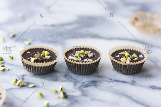 Row of chocolate pistachio butter cups with sea salt