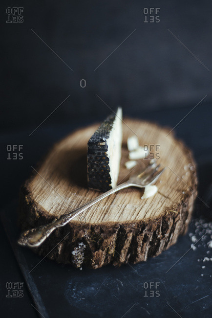 Wedge of cheese on piece of natural wood