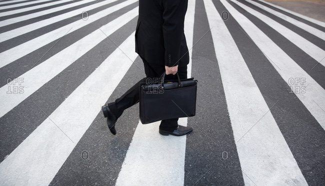 Businessman crossing street in the Shinjuku area of Tokyo, Japan