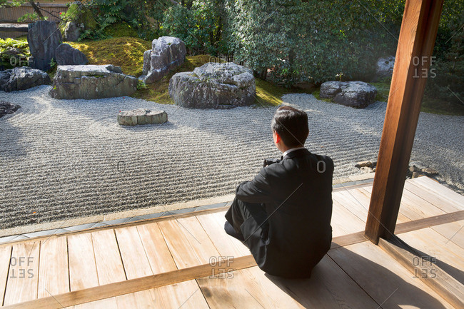 Man sitting in front of zen garden at Tofukuji Temple in Kyoto, Japan