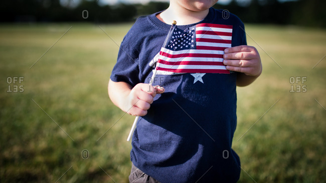 Boy holding American flag to chest