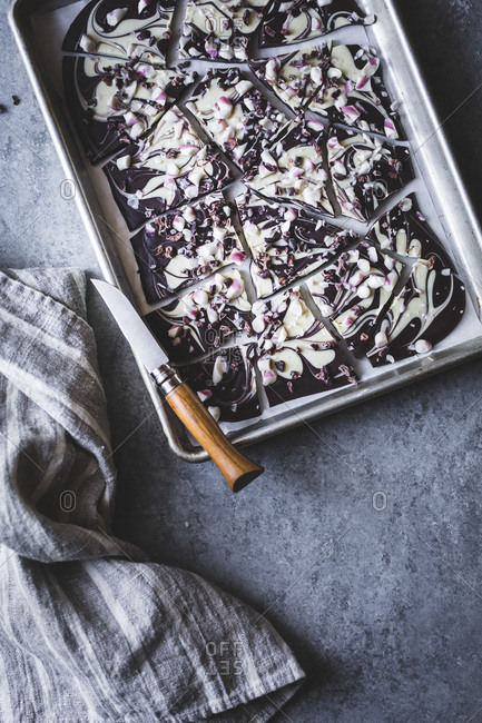 All-natural dark chocolate peppermint bark with cacao nibs and flaky salt on a baking dish