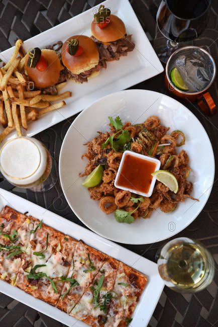 Pizza, sliders, and calamari hors d\'oeuvres served on a table