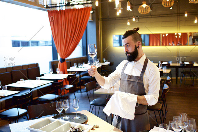 Waiter cleaning a wine glass in a restaurant