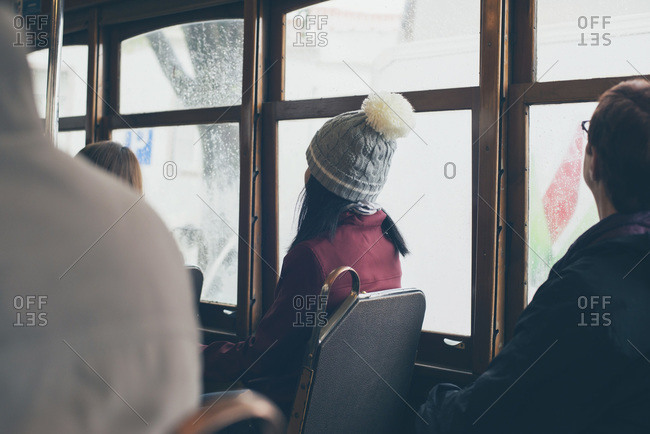 Young woman with a snow hat sitting in a tram in Lisbon, Portugal