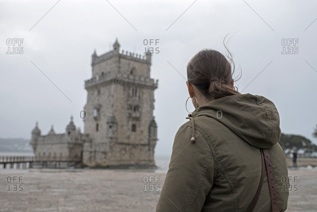 Woman looking at tower on a stormy day in Lisbon, Portugal