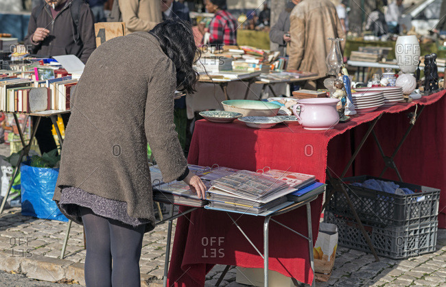 Woman looking at items in a second-hand market in Lisbon, Portugal