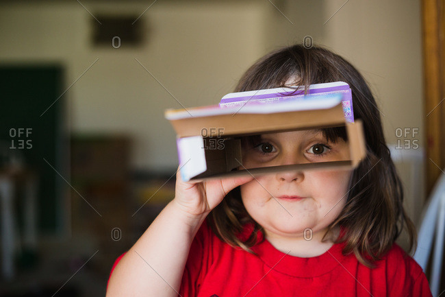 Girl looking through cereal box