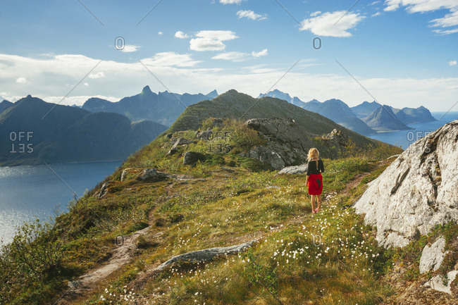 Woman standing at peak of a Norwegian coastal mountain
