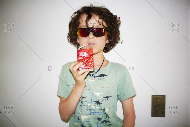 Boy in sunglasses drinking a juice box
