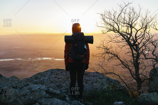 Female hiker in nature looking at view at sunrise