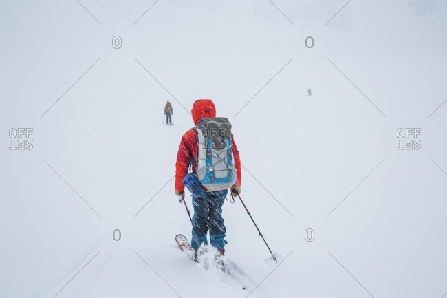 A skier moves quickly as snow falls towards a white horizon during the Spearhead Traverse