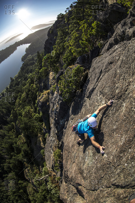 Man in blue rock climbing
