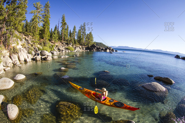 Blonde woman kayaking in Secret Harbor, Tahoe, CA
