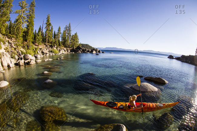 Woman kayaking in Secret Harbor, Tahoe, CA