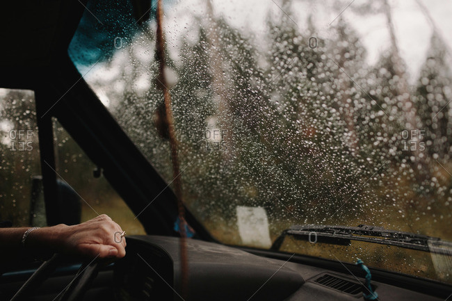 Hand on steering wheel during rain