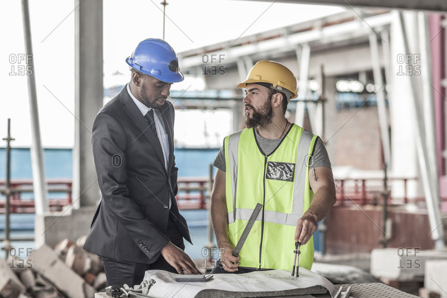 Construction worker and businessman discussing on construction site