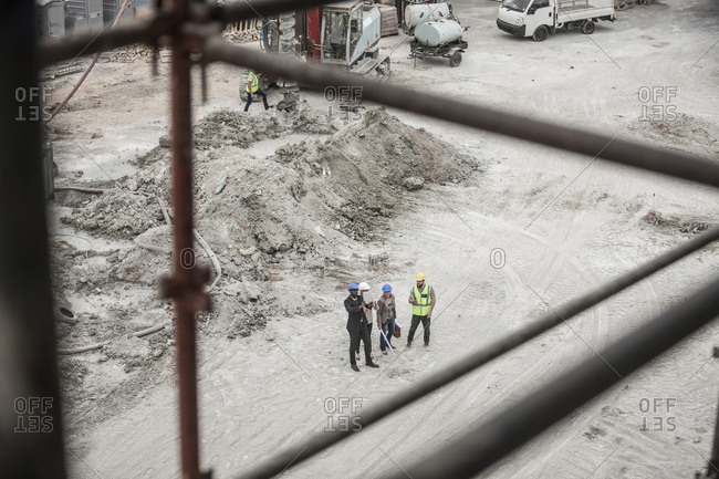 Construction worker and executives talking on construction site
