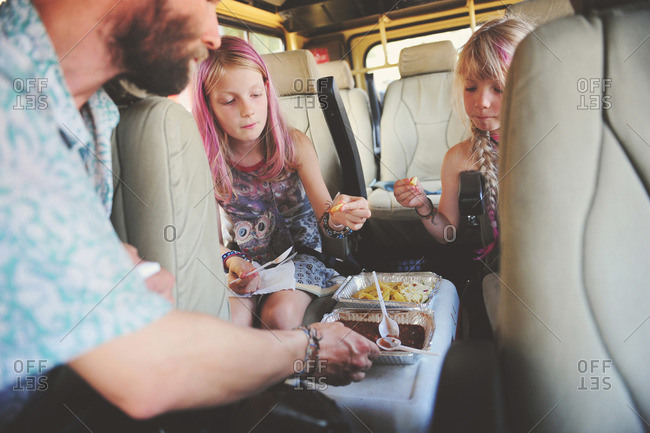 Family eating in van during African tour