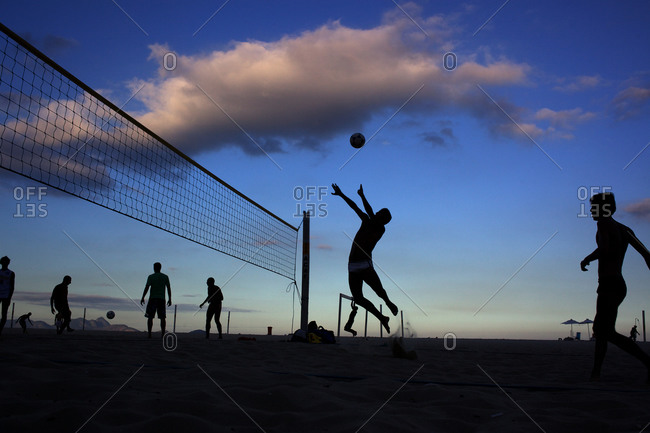 Young men playing volleyball on a sunset beach in Rio de Janeiro