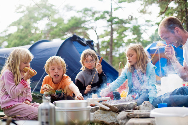 A family eating food outside a tent, Sweden