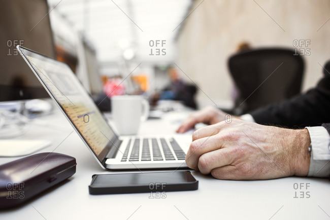Close up of older man working on a laptop