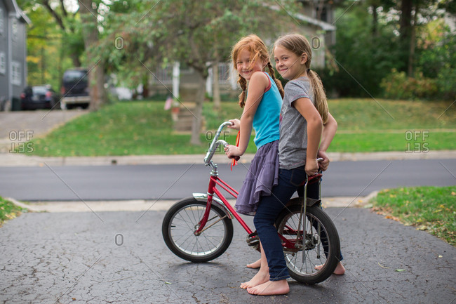 Two girls on a banana seat bicycle