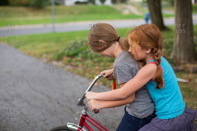 Two girls riding a banana seat bicycle