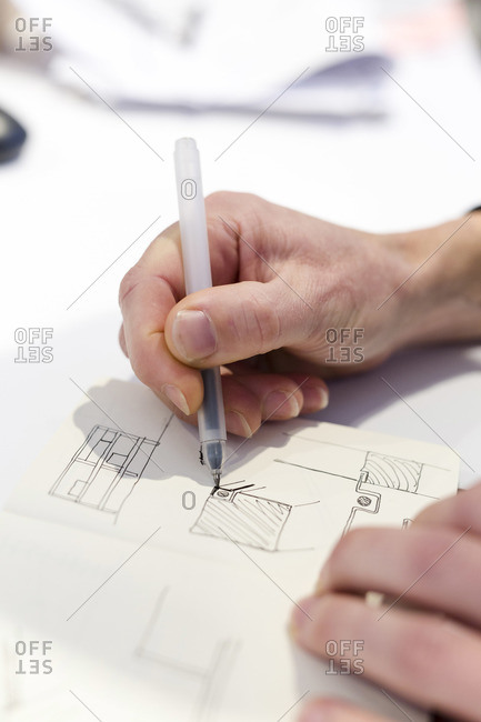 Designer sketching in his notebook inside the factory of a Dutch design furniture brand, Utrecht, The Netherlands