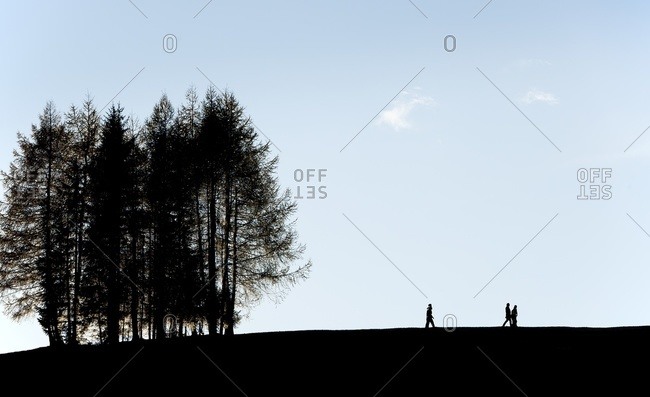 Silhouetted hikers in the Armentara meadows in the South Tryol region of Italy