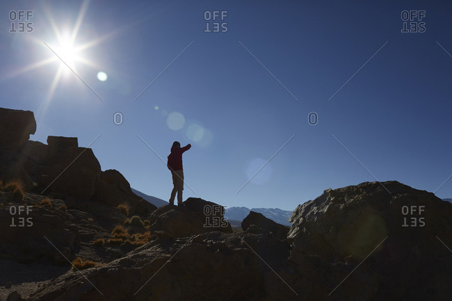 Silhouette of a man climbing a boulder stack in desert mountains