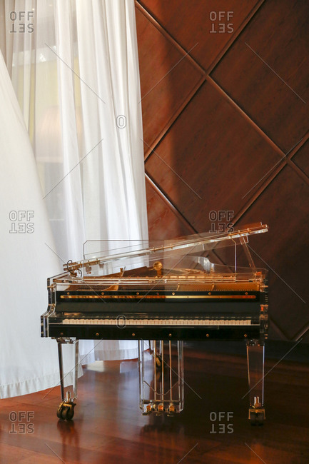Vintage piano by flowing curtains