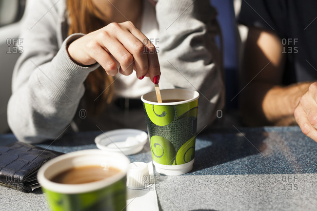 Woman stirring a coffee on train