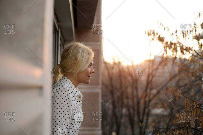 Woman in polka dot blouse standing on a balcony