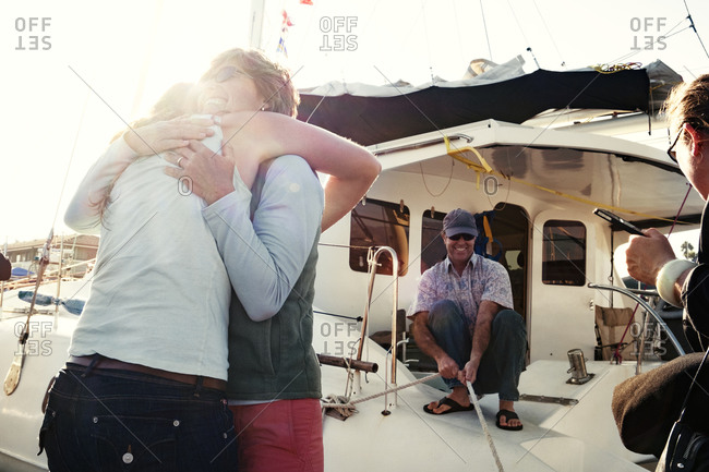 Friends hugging before boarding a boat