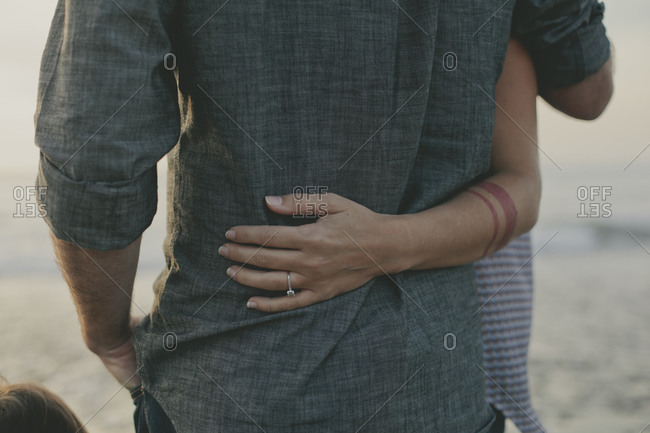 Close up of woman's hand around man's waist