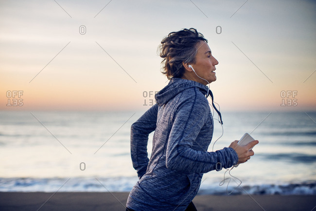 Middle age woman jogging on beach