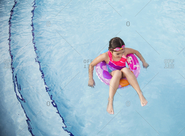 Little girl floating in an inner tube in a swimming pool in Miami, Florida