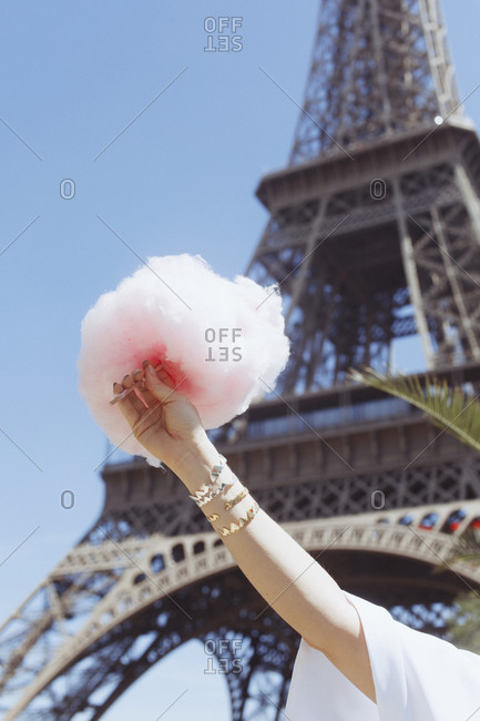 Woman\'s hand holding cotton candy by the Eiffel Tower, Paris